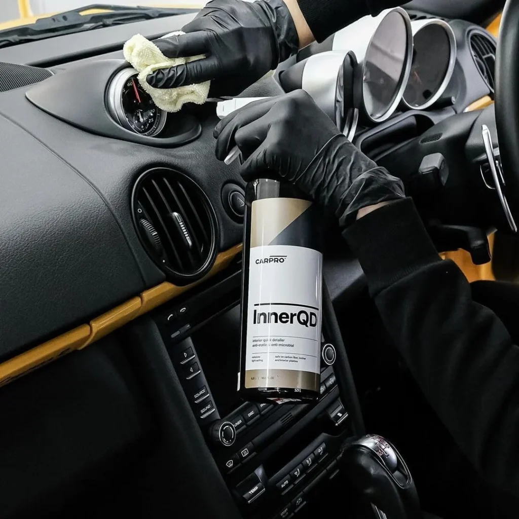 Detailer wiping down a Porsche dashboard during a Premium Interior detail